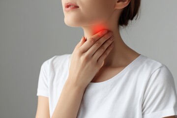 Woman self examining thyroid Close up of her neck with a red mark Thyroid issues may involve goiter hyperthyroidism hypothyroidism tumors or cancer Health concern