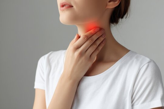 Woman self examining thyroid Close up of her neck with a red mark Thyroid issues may involve goiter hyperthyroidism hypothyroidism tumors or cancer Health concern