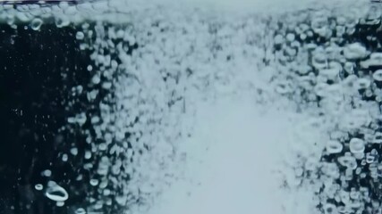 Macro shot of water bubbles rising through clear water, dark background with depth of field - Powered by Adobe