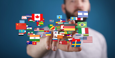 A person pointing towards a collection of floating national flags, representing global...
