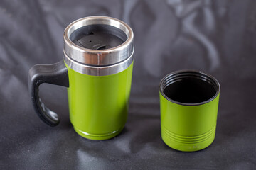 Green travel sippy thermal mug on black background