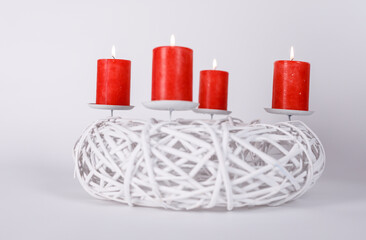 A beautiful image of a burning red candle on a white wreath, perfect for christmas, holiday and peace.