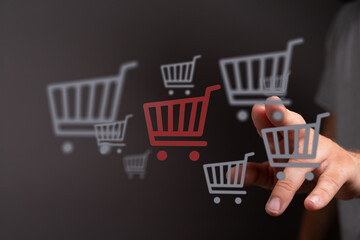 Hand interacting with shopping carts, online shopping and e-commerce concepts for digital stores. Symbolizes purchasing and consumerism in the o
