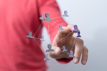 A hand touching a network of interconnected people. Representing concepts like social connection,...