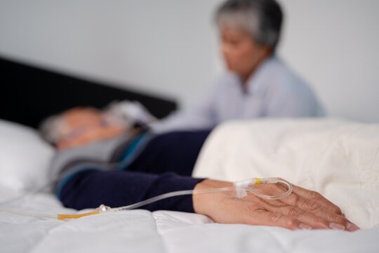 scene of bedridden patient, focus on hand of illness elderly hopeless senior man lying on bed. home caregiver nurse visit retirement patient for health check up recovery process medical service - Powered by Adobe