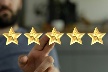 A close-up shot of a hand pointing at five golden stars, representing excellent customer service rating and feedback.
