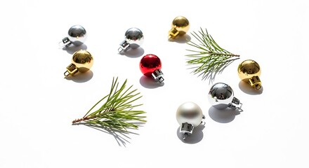 A collection of small, shiny Christmas ornaments in gold, silver, and red, interspersed with pine needles on a white background.