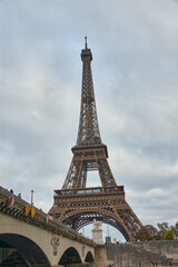Fototapeta premium The Eiffel Tower in Paris, with a wrought iron structure built for the 1889 World's Fair on a gray day