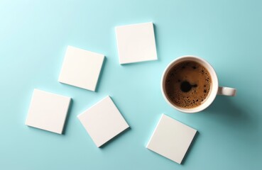 Top view of coffee cup, white coasters on light blue surface. Minimalist style mockup scene for branding templates. Blank templates perfect for advertising design presentation corporate identity.