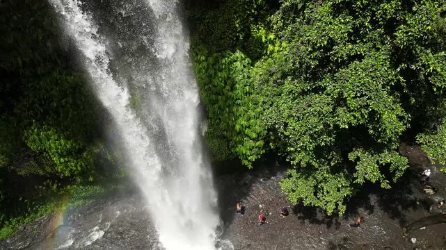 Drone aerial view of Sendang Gile Waterfall in Senaru, Lombok, Indonesia, with tropical rainforest, cascading water and lush natural surroundings.