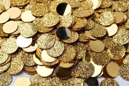 Glittering gold sequins and polished discs overflow a surface - Powered by Adobe