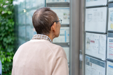 不動産広告を見るシニア男性