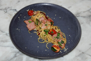 Delicious plate of pasta with meat, basil and tomatoes. A culinary delight served beautifully