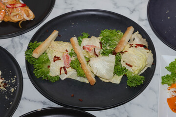 A Delicious Gourmet Salad on a Black Plate