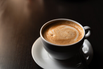 Morning coffee cup on the cafe table in natural morning light