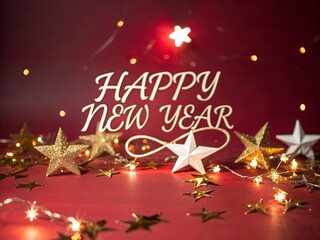 Festive happy new year message with sparkling lights and star decorations on a red background