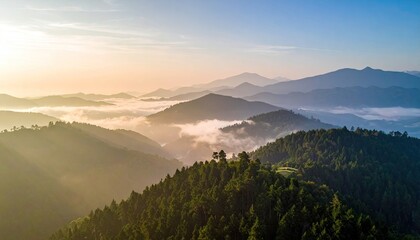 Elevated View of Forested Mountains with Foggy Valleys at Sunrise Under Bright Sky