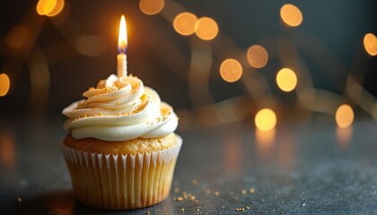 Delicious vanilla cupcake with white cream frosting, golden sprinkles, lit candle. Warm blurred bokeh lights illuminate dark background, creating cozy festive atmosphere. Sweet dessert for birthday