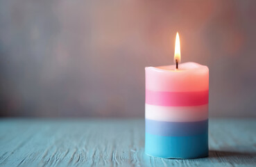 Burning candle with pink blue and white stripes. Represents transgender pride identity and awareness. Soft glow offers comfort and warmth for events.