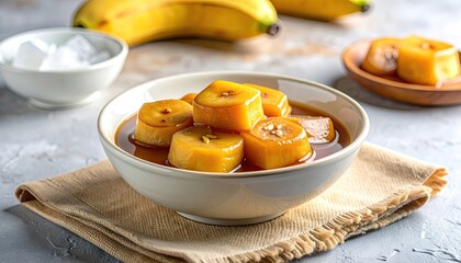 Sri Lankan Aluwa Sesame Sweets in Caramel Sauce Served in a Bowl with Flower Garnish and Bananas in Background