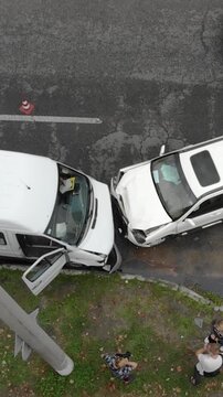 A serious traffic accident involving two white vehicles colliding. The front ends of both vehicles were crushed. Drone view. Insurance, road safety, and transport