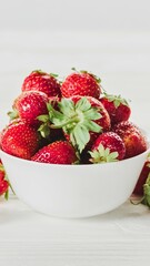 Fresh ripe strawberries piled high in a white bowl