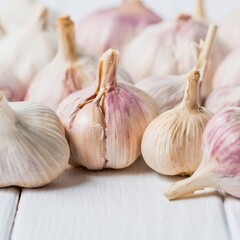 Freshly harvested garlic bulbs on a white wooden surface