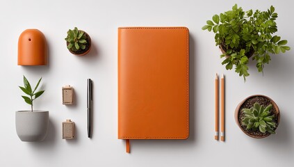 Desk flatlay orange notebook, plants, pen, and pencils