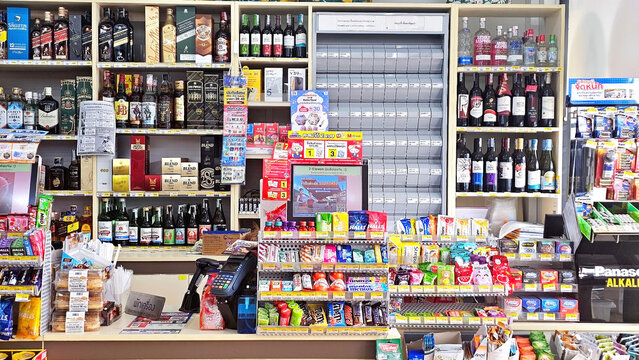 Convenience Store Interior: A Store's Diverse Array: Inside a well-stocked 7-Eleven convenience store counter, with shelves full of food, drinks, and daily essentials. Thailand, October 18, 2025