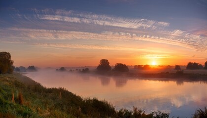 Obraz premium Tranquil Riverside at Dawn with Cirrus Clouds and Orange Sunrise Reflection 