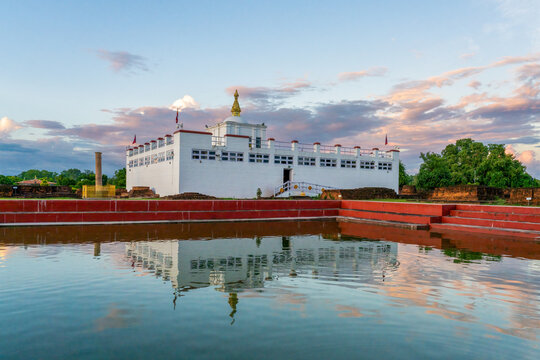 Maya Devi Temple with Ashoka Pillar and it's reflection in sacred bathing pond in Lumbini, Nepal. The exact birthplace of Lord Buddha Siddhartha Gautama and one of the Eight Great Places of Buddhism.
