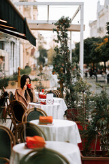 Woman enjoys coffee in a cozy Italian cafe with outdoor seating in the afternoon light
