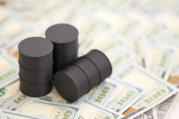 Barrels of oil on bills of American dollars. purchase, sale of oil concept close up