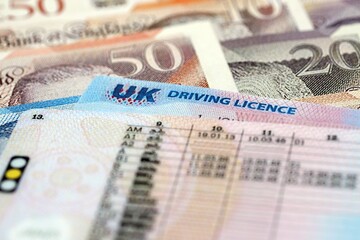 United Kingdom driving license card on UK British pounds money close up