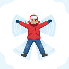 A young boy in winter clothing lying on the snow making a snow angel.