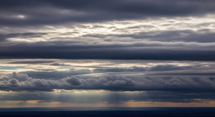 Dramatic sky with sun rays breaking through dark clouds at sunset