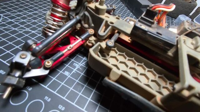 Top-angle footage of testing a toy car's wheel drive servo. Videography of the servo mechanism that drives the wheels to turn left and right. Repair and maintenance of toy hobby RC cars in 4K Footage
