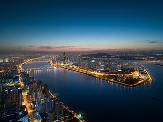 Aerial View of a Vibrant Coastal City at Dusk, Illuminated by Urban Lights Reflecting on the Water