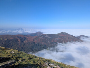 Vista deslumbrante das montanhas outonais de Artzamendi em Itxassou, com um mar de neblina sob um céu azul em França © LuIvDa