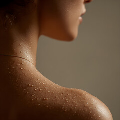 Close-up of female shoulder with water droplets, skincare and wellness concept