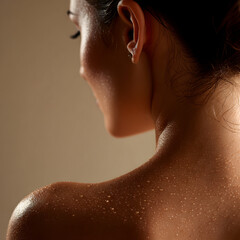 Close-up of a woman’s back and neck with water droplets on glowing skin, wellness and beauty concept