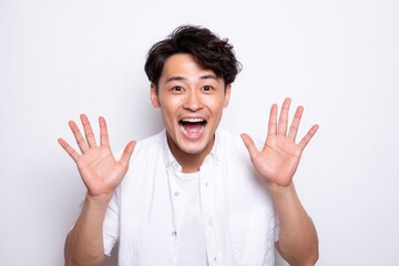 Thrilling Wow Experience: Excited Young Asian Male Expressing Happiness with an Enthusiastic Gesture Against a Bright White Background