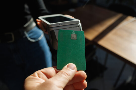 Contactless bank card near wireless POS terminal for secure retail checkout