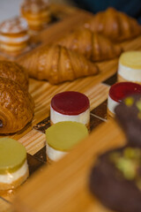 “Assorted artisanal desserts and pastries displayed on wooden table in modern bakery”