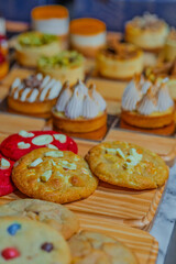 “Assorted artisanal desserts and pastries displayed on wooden table in modern bakery”