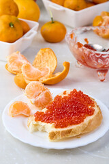 Sandwich with red caviar and tangerines. Traditional Russian treat on the New Year's table.