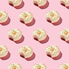 Overhead view of various donuts with confetti arranged on colored background