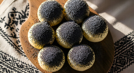 Freshly Baked Poppy Seed Buns Displayed on a Wooden Board with Decorative Textile