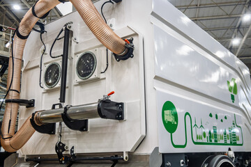 Modern white street sweeper truck detail with a large vacuum hose and eco-friendly graphics, representing urban cleaning, sanitation, and sustainable city maintenance. © dizfoto1973