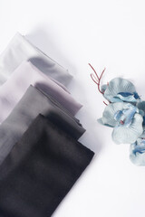 A collection of black, white, and gray headscarves rests on a bright white background.